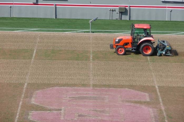 A sports field with a tractor on it.