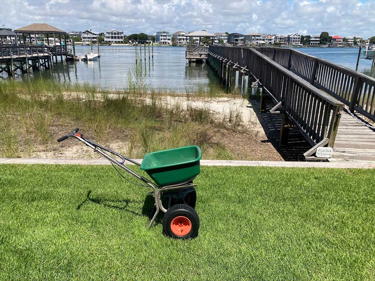coastal-lawn-care image of a fertilizer spreader on a coastal lawn