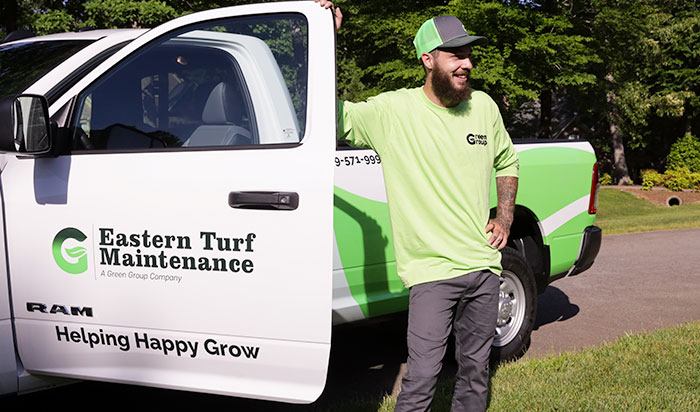 raleigh-page-title Man smiling next to a E.T.M truck.